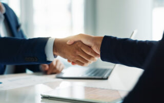 Business people, closeup and handshake for deal, agreement and partnership negotiation in office.