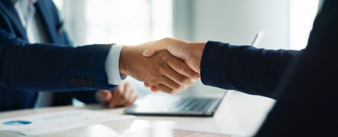 Business people, closeup and handshake for deal, agreement and partnership negotiation in office.